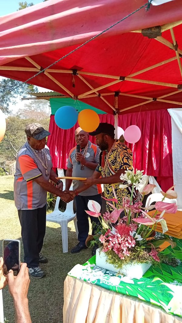 A participant receiving a certificate at the Community Curriculum graduation. Foursquare Gospel Church, Lower Asaro, Eastern Highlands. August 2026.